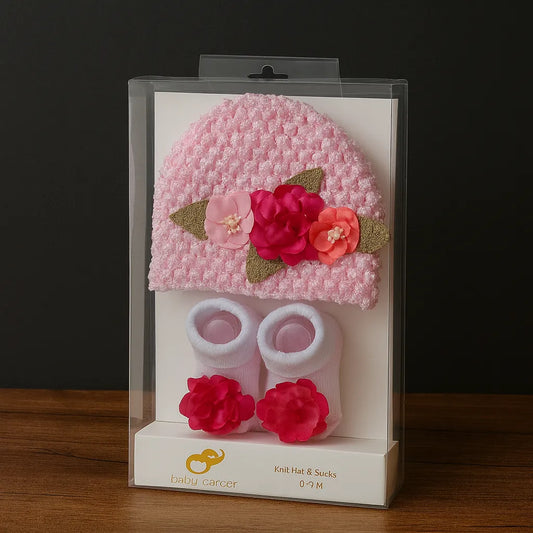 Baby knit hat and socks set in clear packaging on a dark background