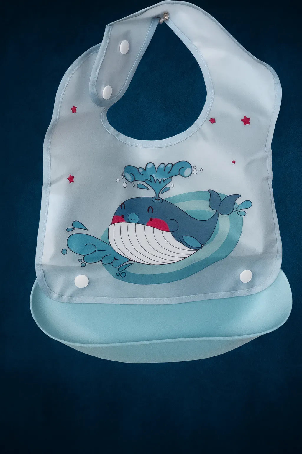 Children's bib with whale design on a dark blue background
