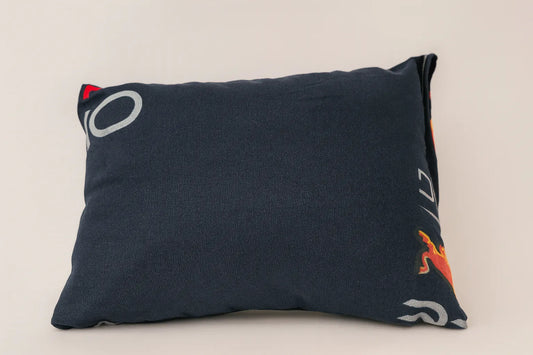 Navy blue pillow with colorful designs on a beige background