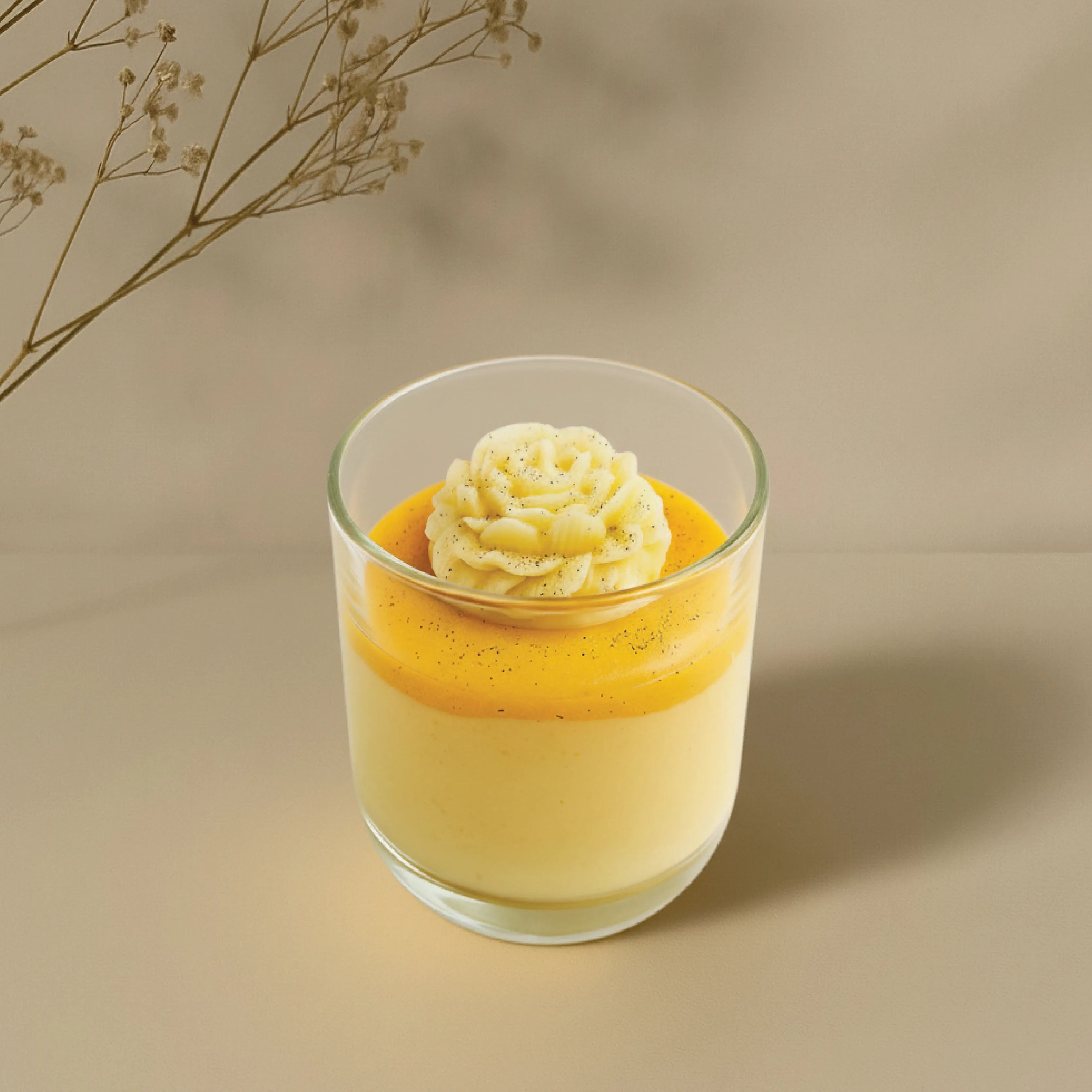 Glass with layered dessert on a beige background
