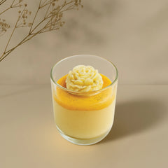 Glass with layered dessert on a beige background
