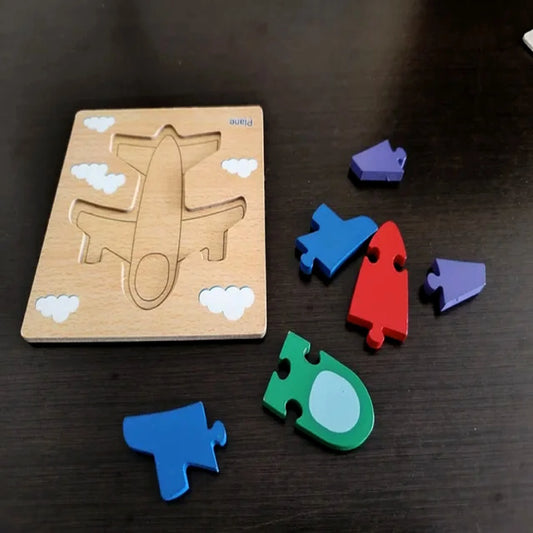 Wooden airplane puzzle with colorful pieces on a dark surface